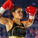 Supernova-genesis-alana • Guadalupe Informa Female Boxer in Black and Gold Outfit Raises Red Gloves in Victory Pose Inside a Arena with Cheering Crowd Behind Her. • Guadalupe Informa