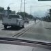 View from a Car: a White Pickup in the Left Lane Ahead, Cyclist in the Center of the Road on an Urban Street. • Guadalupe Informa