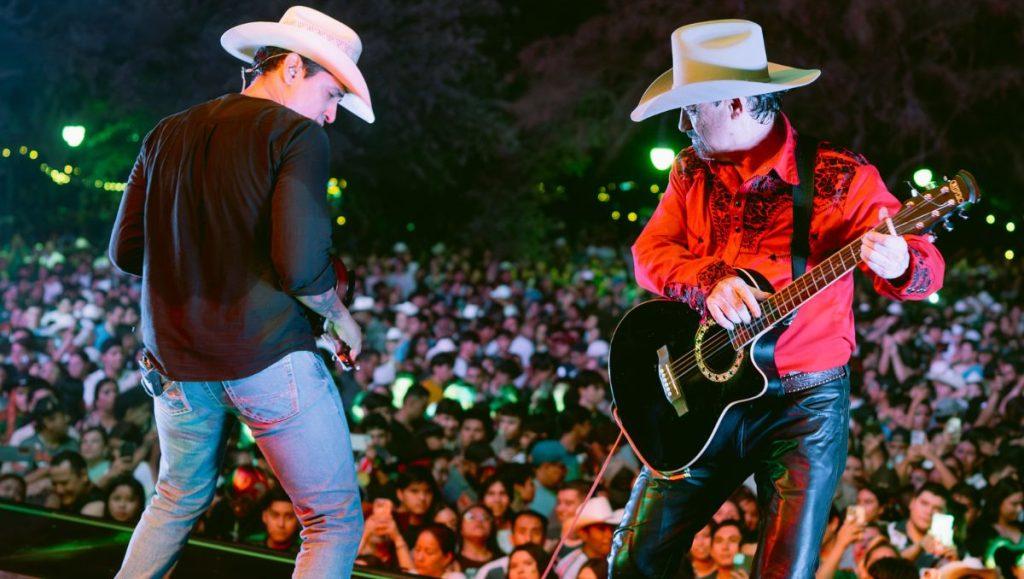 Payaso-de-rodeo-monterrey • Guadalupe Informa Two Country Musicians Wearing Cowboy Hats Perform on a Crowded Outdoor Stage at Night. • Guadalupe Informa