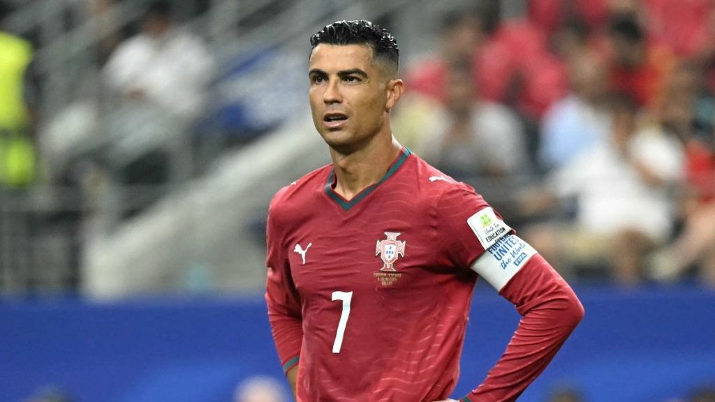 Portugal Captain Cristiano Ronaldo in a Red Jersey (#7) on the Pitch with a Blurred Stadium Crowd Behind Him. • Guadalupe Informa