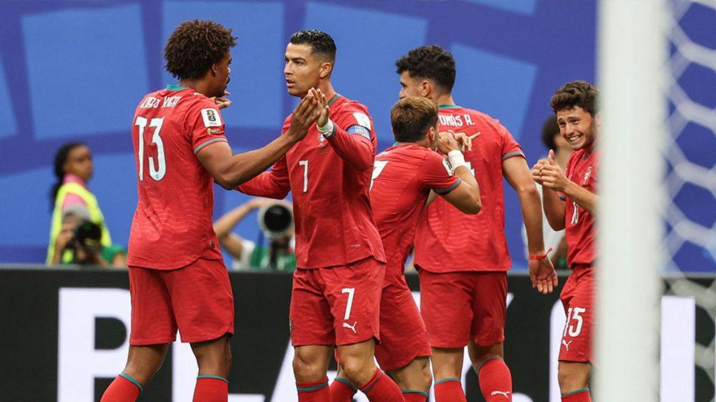 Soccer Players in Red Uniforms Celebrate a Goal on the Field, High-fiving Near the Goalpost; Visible Numbers Include 13 and 7 on the Jerseys. • Guadalupe Informa