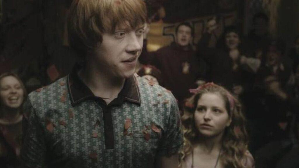 Lavender-brown-harry-potter • Guadalupe Informa Young Man in a Teal Patterned Shirt Stands in the Foreground at a Crowded Party or Social Gathering. • Guadalupe Informa