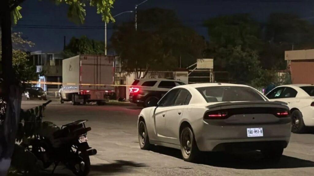 Night Scene on a Street with a Gray Dodge Charger in the Foreground and Police Tape Cordoning off the Area Behind It. • Guadalupe Informa