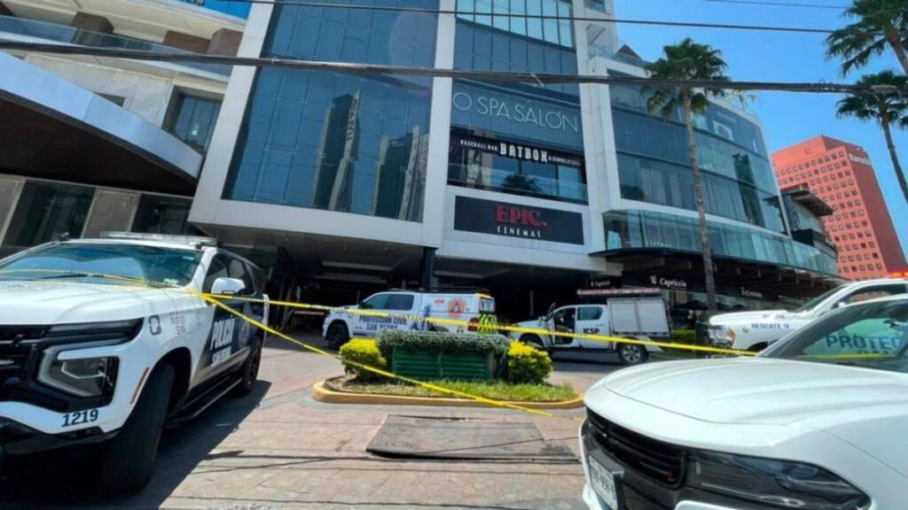 Police Scene Outside a Shopping Center with Yellow Caution Tape, Multiple Patrol Vehicles Parked in Front of a Glass-front Building with Epic Cinemas Sign. • Guadalupe Informa